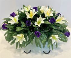 a vase filled with white and purple flowers