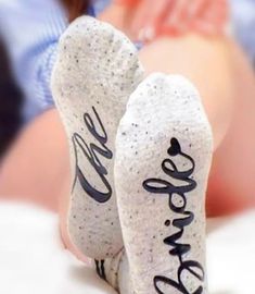 someone has their feet up on the bed with socks that say we are married and there is a woman's stomach in the background