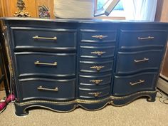 a blue dresser with gold trim and drawers