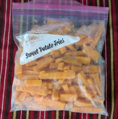 a bag of sweet potato fries sitting on top of a red and yellow striped table cloth