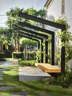 a wooden bench sitting in the middle of a lush green yard