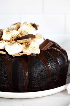 a chocolate bundt cake with marshmallows and chocolate sauce on the top