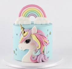 a cake decorated with a rainbow and clouds