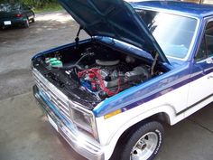 an old pickup truck with its hood open and the engine in it's trunk