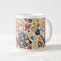 a white coffee mug with colorful flowers and birds on it