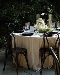 the table is set with white flowers and wine glasses