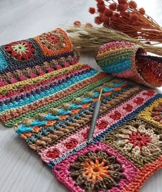 two crocheted potholders, one with flowers and the other with yarn