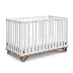 a white crib with wooden legs and no mattress on the bottom, against a white background