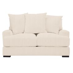 a white couch with four pillows on it