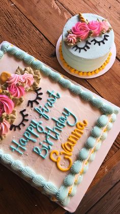 two birthday cakes with frosting and flowers on them sitting on top of a wooden table