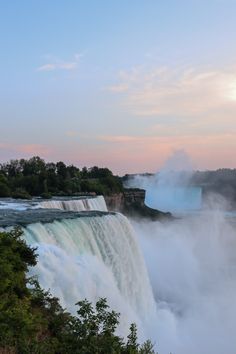 the niagara falls at sunset with mist coming from them