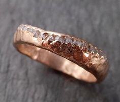 a close up of a gold ring with rough diamonds on it's sides and in the middle