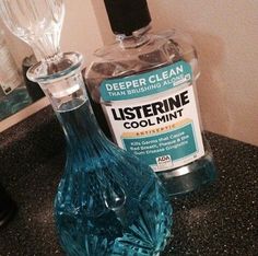 a bottle of listerine and a glass vase on a counter