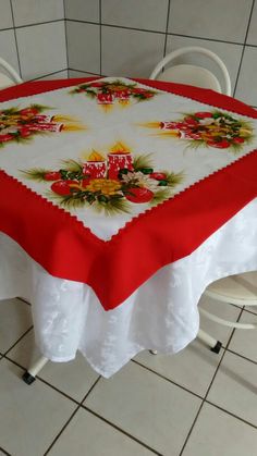 a table with a red and white table cloth on it in a room filled with tile flooring