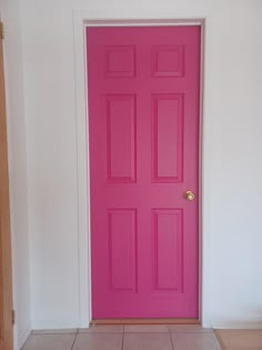 a bright pink door in a white room