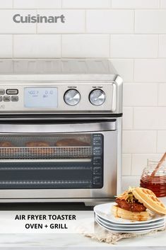 a silver toaster oven sitting on top of a counter next to a plate of food