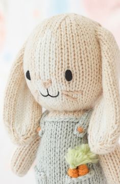 a knitted bunny doll with carrots in its pocket