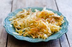 a blue plate topped with sauerkraut on top of a wooden table