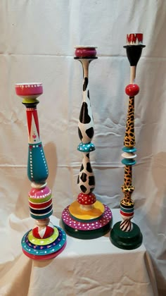 several different colored candlesticks on a table