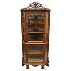 an antique display cabinet with glass doors and carvings on the top, in walnut wood