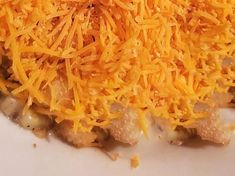 a white plate topped with meat and cheese covered in grated cheese on top of it