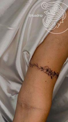 a woman's arm with flowers on it and the word love written in cursive writing