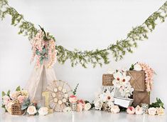 a white table topped with lots of flowers next to a teepee and other items