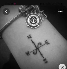 a black and white photo of a compass tattoo on someone's arm with the word love written across it