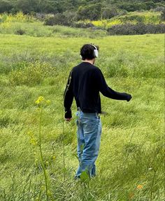 a man standing in the middle of a lush green field