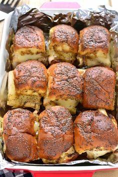 a red dish filled with chicken and cheese sliders on top of foil covered in seasoning