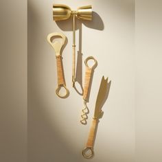 three pairs of scissors are hanging on the wall next to each other with gold handles