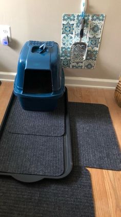 a blue litter box sitting on top of a wooden floor