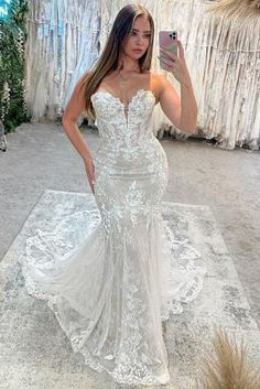 a woman taking a selfie while wearing a wedding dress in front of a store display