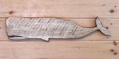 a wooden plank with a metal whale on it