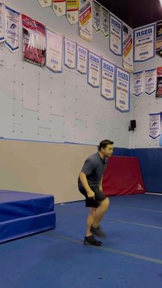 a man standing on top of a blue wrestling mat