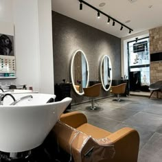 a hair salon with chairs, mirrors and sinks