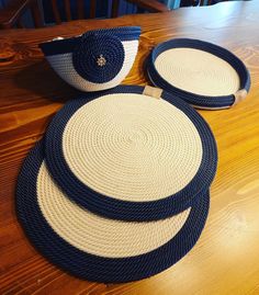 three blue and white baskets sitting on top of a wooden table