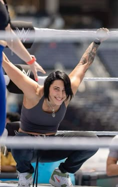 a woman is sitting on the ground with her arm in the air