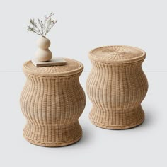 two wicker baskets with lids and vases on the top one has a plant in it