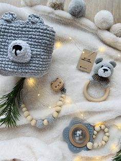 two knitted teddy bears are sitting on a blanket next to some beads and buttons