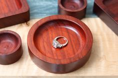 a wooden box with a ring on it and other items in the case around it