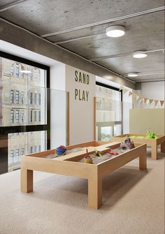 an indoor play area with sand and water in the center for children to play on