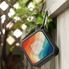 a bluetooth speaker hanging from the side of a wall