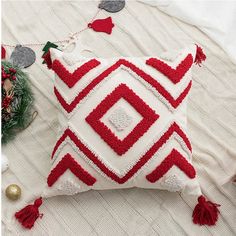 a red and white pillow sitting on top of a bed next to christmas decorations,