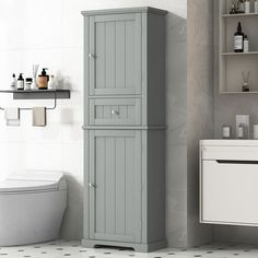 a white toilet sitting next to a tall gray cabinet