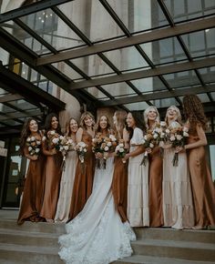 a group of women standing next to each other in front of a building with flowers