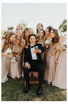 a group of bridesmaids pose for a photo with the groom in a tuxedo