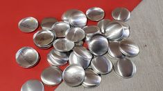 a pile of silver spoons sitting on top of a red table