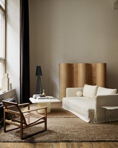 a living room filled with furniture next to a window and a lamp on top of a table