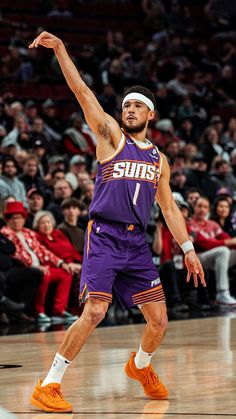 a man in purple jersey and orange shoes playing basketball